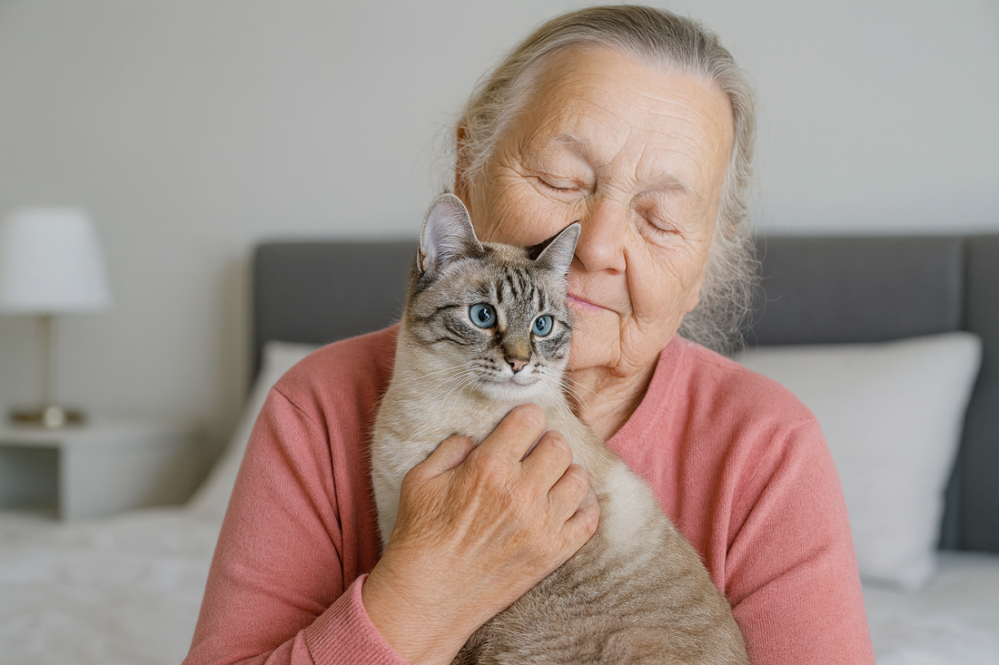 Dame âgée portant un pull rose câlinant un chat dans une chambre moderne – Litière Pacha
