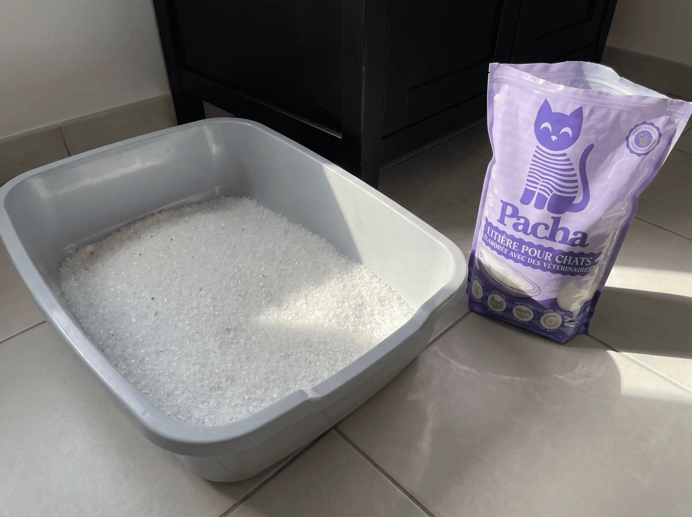 Bac rempli de cristaux Pacha blancs, sac violet à côté, rayon de soleil, air parfaitement clair